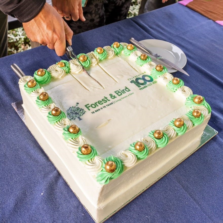 Forest & Bird's centenary birthday cake is being cut.