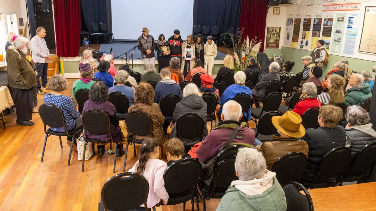 Diverse community gathering at a cultural event in Paekākāriki, New Zealand, featuring local residents and visitors engaging in storytelling and presentations about the area's history and heritage.