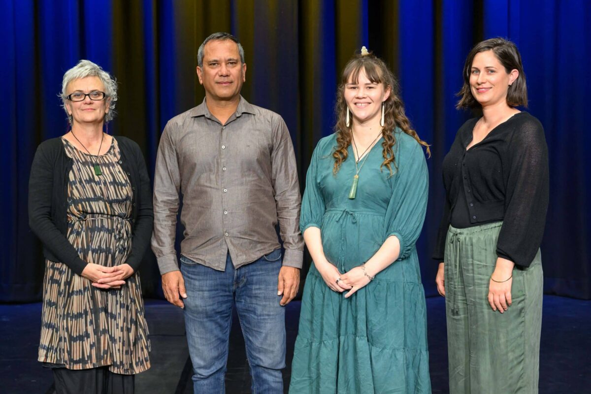 The four elected community board members of Paekākāriki stand in front of a blue background